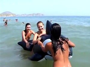 Nackte Mädchen am Nacktstrand mit aufblasbarem Wal, nackte Mädchen