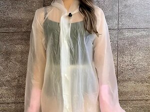 ein Mädchen wäscht ihren Körper mit einem Regenmantel.