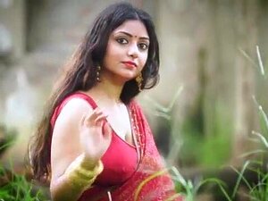 Fickende indische Tante Rupashree in rotem Sari draußen